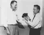 Two men holding a model